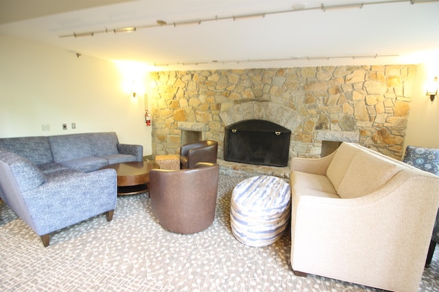 carpeted living area featuring a stone fireplace