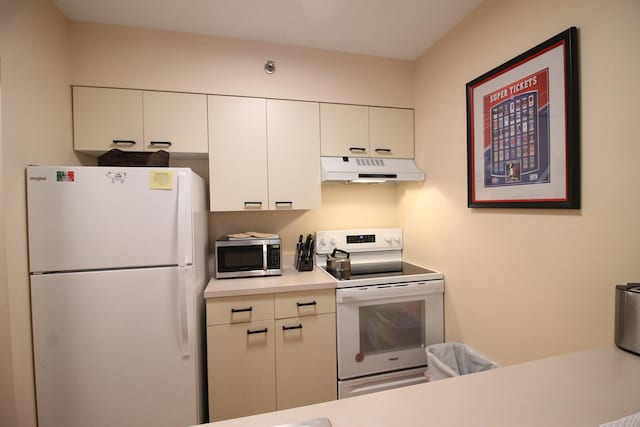 kitchen with white appliances, light countertops, under cabinet range hood, and white cabinetry