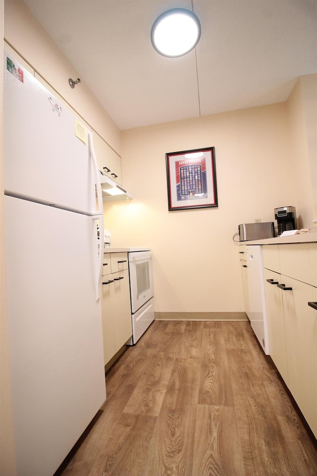 kitchen featuring light countertops, light wood-style floors, white cabinetry, white appliances, and baseboards