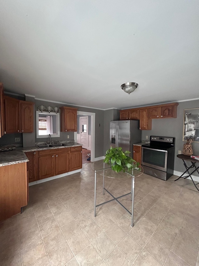 kitchen featuring stainless steel appliances, brown cabinetry, ornamental molding, a sink, and baseboards