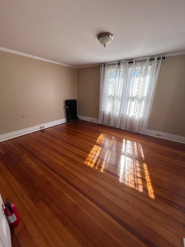 unfurnished living room featuring ornamental molding, baseboards, and wood finished floors