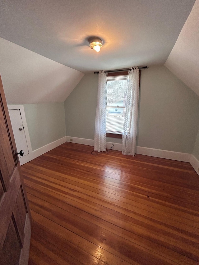 bonus room featuring lofted ceiling, baseboards, and hardwood / wood-style floors