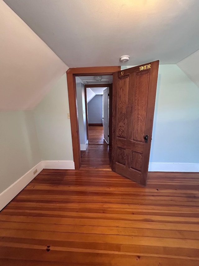 bonus room featuring lofted ceiling, baseboards, and wood finished floors