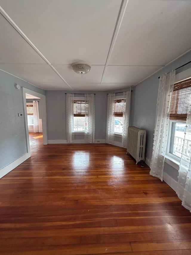 interior space with baseboards, radiator heating unit, and hardwood / wood-style flooring