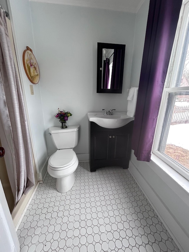 full bathroom featuring a stall shower, vanity, toilet, and baseboards