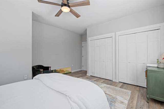 bedroom with two closets, a ceiling fan, and light wood finished floors