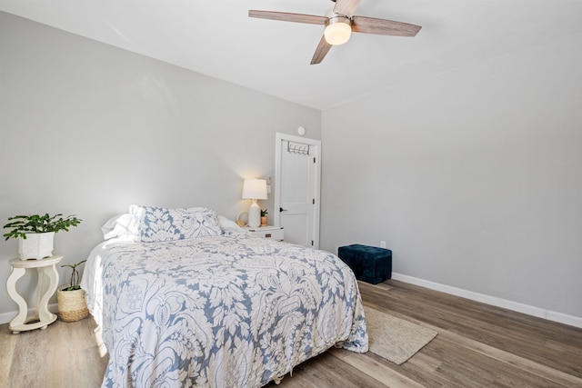 bedroom with ceiling fan, baseboards, and wood finished floors