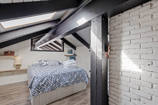 unfurnished bedroom featuring vaulted ceiling with beams, wood finished floors, wood walls, and brick wall