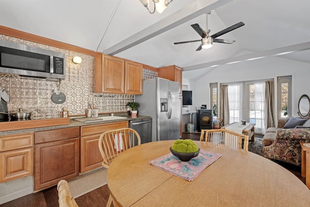 kitchen featuring open floor plan, appliances with stainless steel finishes, french doors, and vaulted ceiling