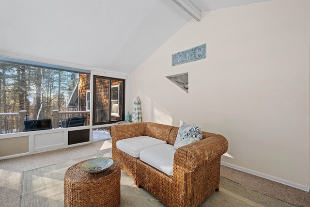 living area featuring carpet flooring, baseboards, and vaulted ceiling with beams