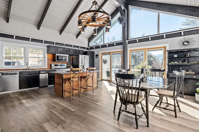 interior space featuring a wealth of natural light, beam ceiling, wooden ceiling, and light wood-style floors