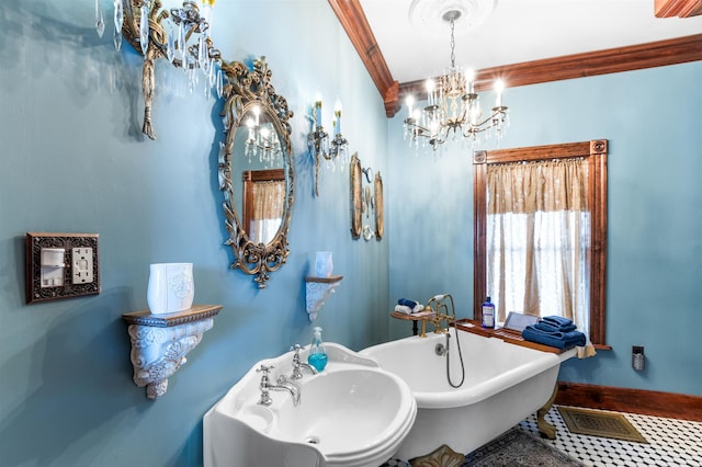 full bath featuring a freestanding tub, a sink, visible vents, baseboards, and ornamental molding