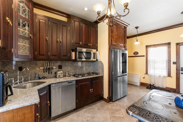 kitchen with light tile patterned floors, appliances with stainless steel finishes, a sink, crown molding, and backsplash