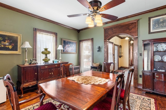 dining space featuring dark wood-style floors, ornamental molding, and a wealth of natural light