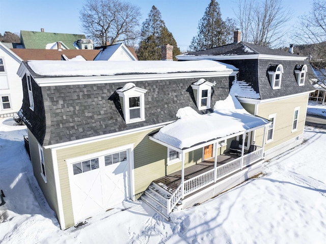 view of front of property featuring a porch, a shingled roof, and a garage