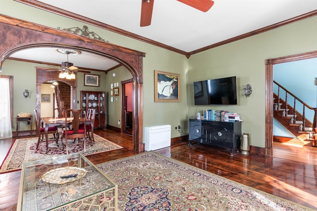 living room with arched walkways, ceiling fan, stairway, and wood finished floors