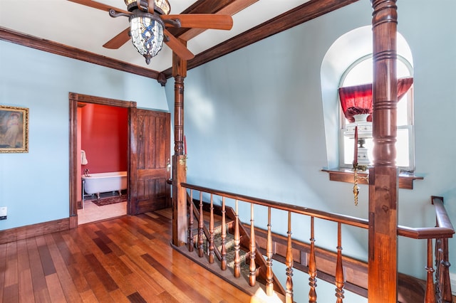 corridor with baseboards, ornamental molding, hardwood / wood-style floors, and an upstairs landing