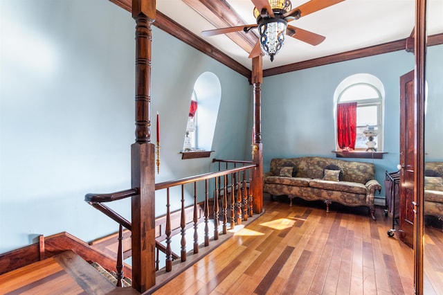 living area with wood-type flooring, crown molding, an upstairs landing, and ceiling fan