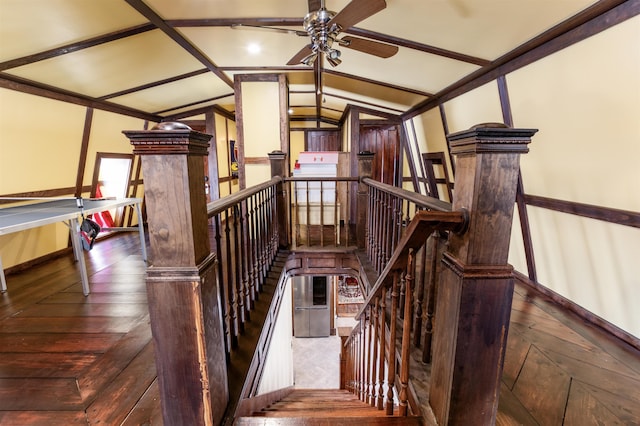 stairs featuring lofted ceiling, wood-type flooring, baseboards, and ceiling fan