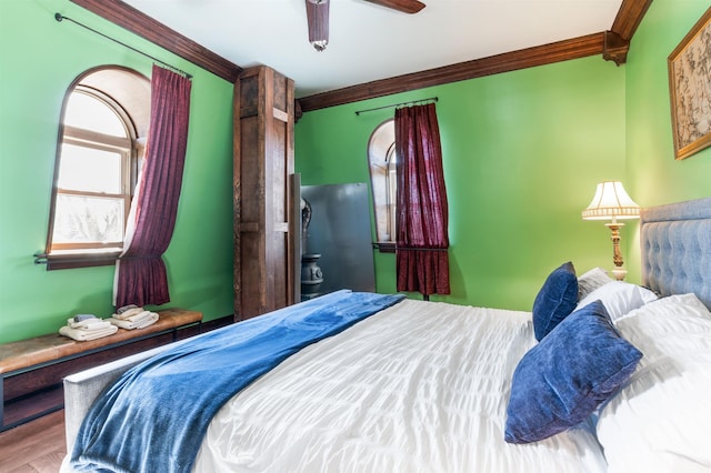 bedroom featuring ornamental molding, wood finished floors, and a ceiling fan