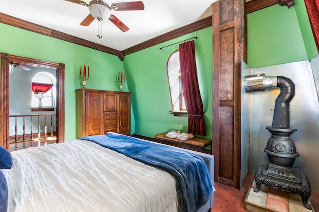 bedroom with ceiling fan, ornamental molding, and wood finished floors