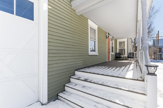 snow covered deck featuring a porch