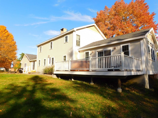 back of house with a lawn and a wooden deck