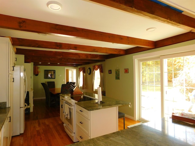 kitchen with beamed ceiling, white cabinetry, wood finished floors, white appliances, and plenty of natural light