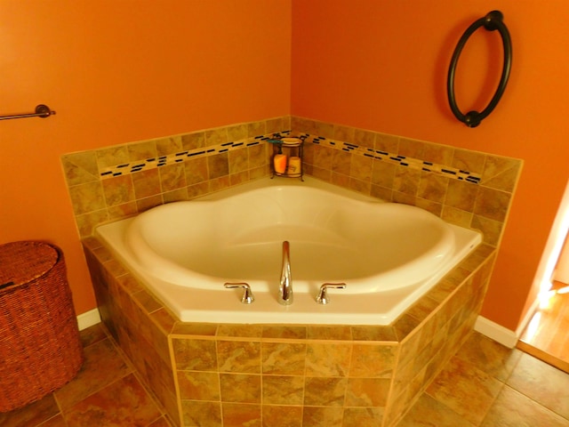 full bathroom with a garden tub, tile patterned flooring, and baseboards