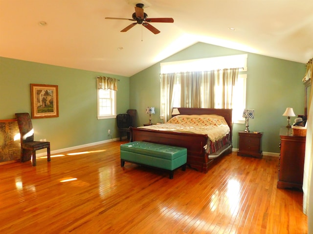 bedroom featuring baseboards, vaulted ceiling, light wood finished floors, and ceiling fan