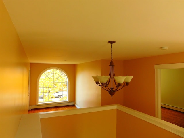 details featuring a baseboard radiator and a notable chandelier