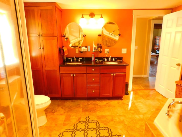 full bath featuring a shower with shower door, a sink, baseboards, and double vanity