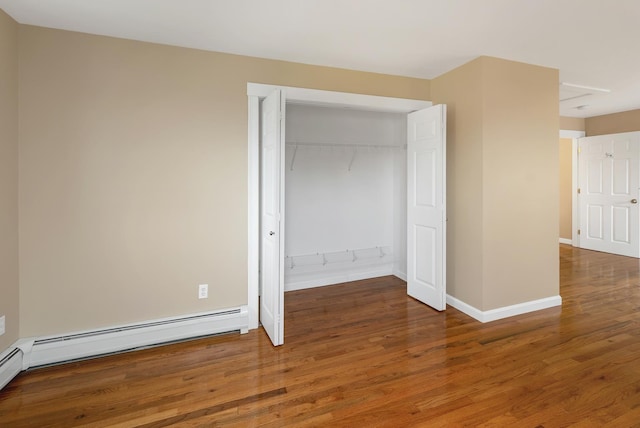 26 Hilltop Dr, Wakefield, NH 03872 - unfurnished bedroom featuring wood finished floors, a closet, baseboards, and a baseboard radiator
