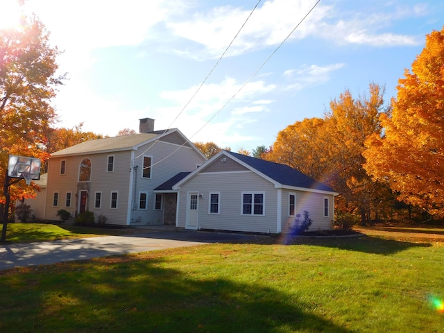 view of front of home with a chimney and a front yard