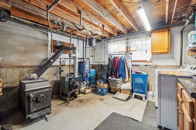 below grade area with washer and dryer, a wood stove, and a heating unit