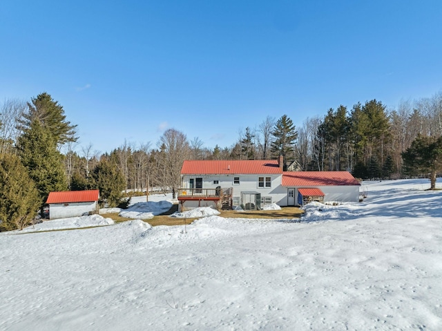 exterior space with metal roof, a chimney, and a deck