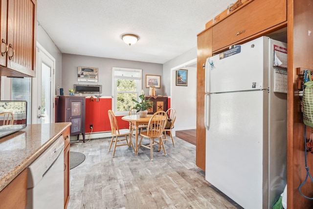 kitchen featuring light stone counters, light wood-style floors, a baseboard heating unit, a textured ceiling, and white appliances