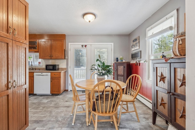 dining area with a baseboard heating unit and french doors