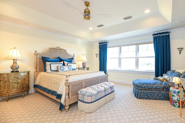 carpeted bedroom with a tray ceiling, recessed lighting, visible vents, and baseboards