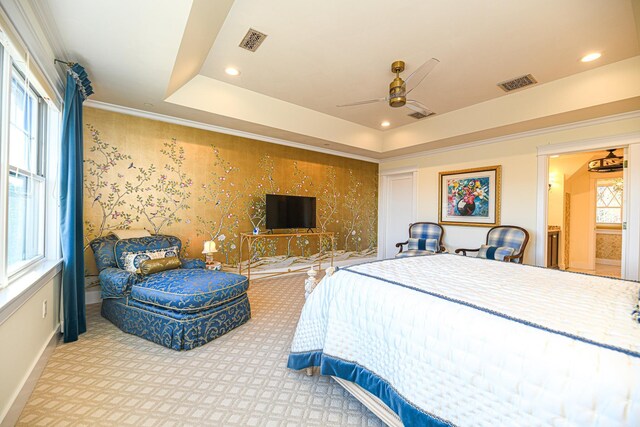 carpeted bedroom with a tray ceiling, visible vents, multiple windows, and wallpapered walls