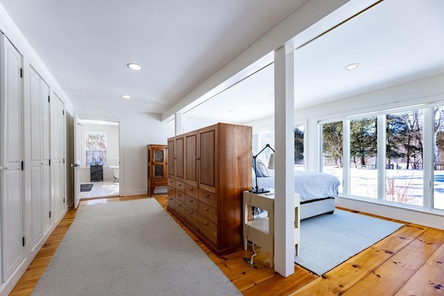 bedroom featuring baseboards, light wood finished floors, connected bathroom, and recessed lighting