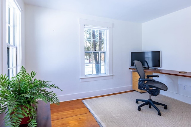 office space with wood finished floors and baseboards