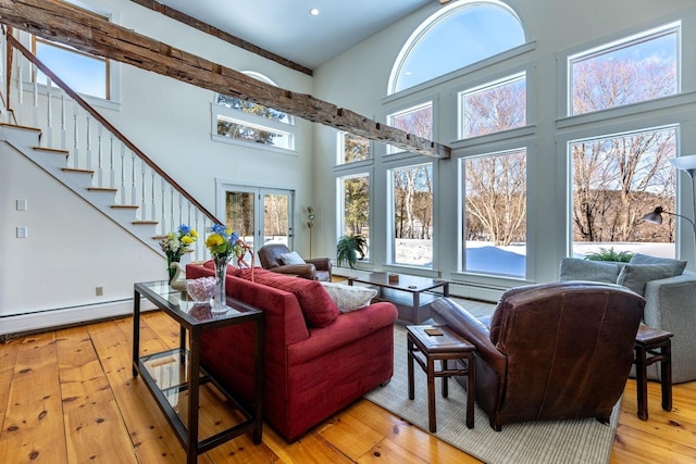 living area featuring wood-type flooring, a high ceiling, stairway, and french doors