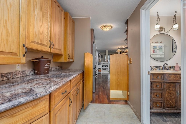 kitchen featuring stone counters, a sink, and light tile patterned flooring