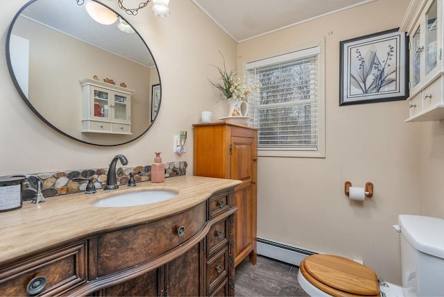 bathroom with baseboard heating, vanity, toilet, and wood finished floors