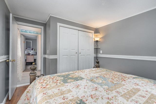 bedroom featuring dark wood-style floors, attic access, a closet, and crown molding