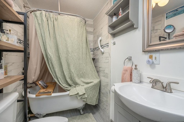 full bathroom with a textured ceiling, toilet, wood finished floors, vanity, and shower / bath combo with shower curtain