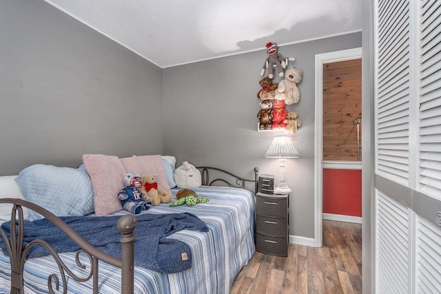 bedroom with wood finished floors and baseboards