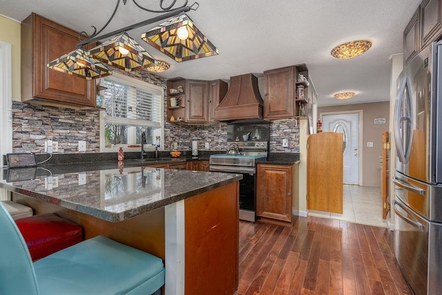 kitchen featuring stainless steel appliances, premium range hood, a breakfast bar, a sink, and open shelves