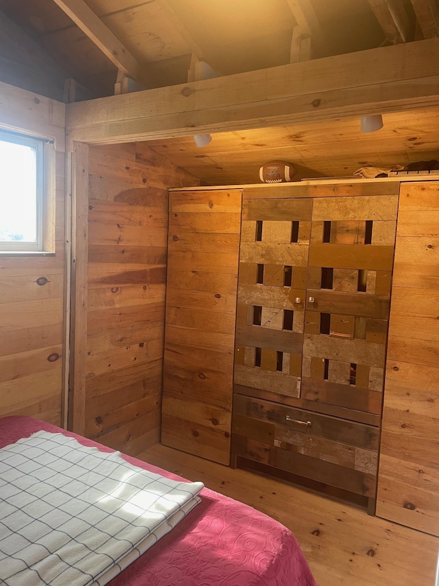 bedroom with wood walls and wood finished floors